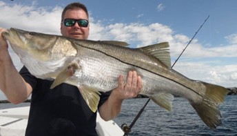 Captain Dave Pomerleau (The Mad Snooker) holding a large fish