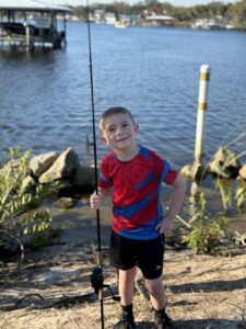 A child posing with a fishing pole